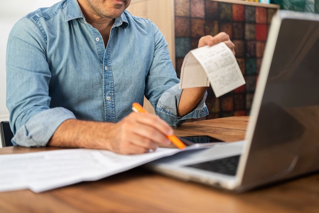 middle-aged-man-calculating-taxes-at-a-wooden-desk-2024-12-05-20-22-24-utc.jpg