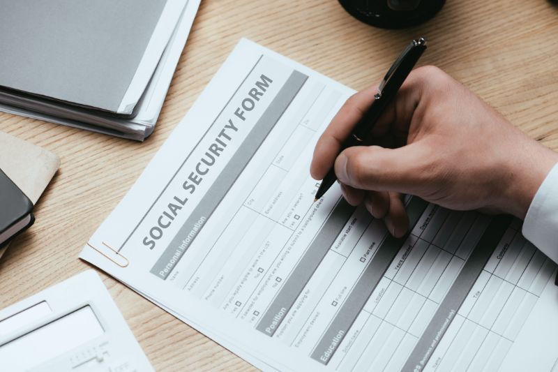 A freelancer completing social security registration paperwork for employment compliance.